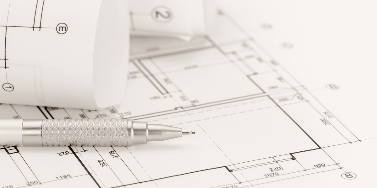 architect workspace with rolled floor plans and blueprints